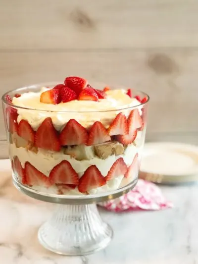 The Best Strawberry Trifle Recipe: layers of Grand Marnier soaked angel food cake, real whipped cream mixed with vanilla pudding and strawberries! #TrifleRecipe #PatrioticRecipe #LayeredDessert #Dessert #SummerDessert #BoozyCake #BoozyDessert