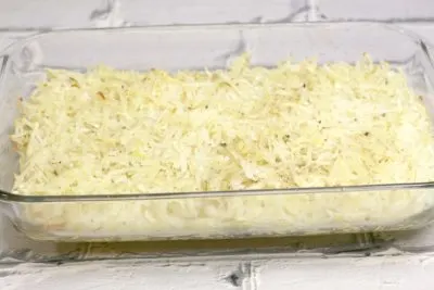 Pouring hash browns into a 9x13-inch baking dish.