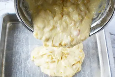 Pouring fruit cocktail cake batter before baking. Pouring fruit cocktail cake batter before baking.