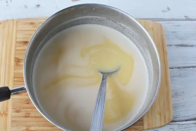 Stirring butter, sugar and evaporated milk together. Stirring butter, sugar and evaporated milk together.