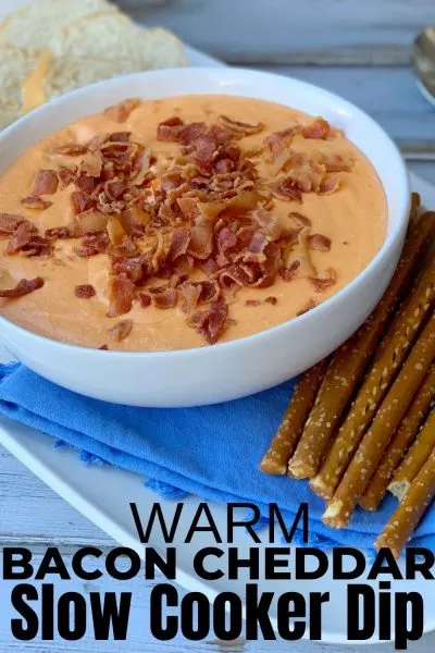 Warm and creamy, everyone loves this Hot Bacon Cheddar Slow Cooker Dip! Toss everything and stir, then serve with your favorite dippers. It's perfect for game day or cocktail hour. #SlowCooker #HotDipRecipe #WarmDipRecipe #SuperBowlRecipe #BaconDip
