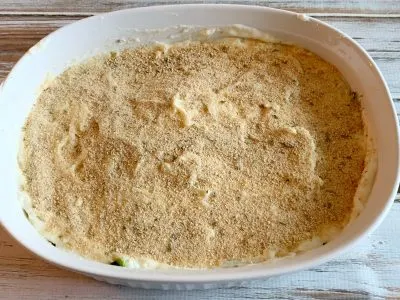 Adding breadcrumb mixture on top of casserole dish