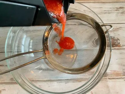 Straining strawberry puree Straining strawberry puree