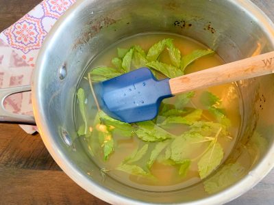 Adding lemon and mint leaves to simple syrup
