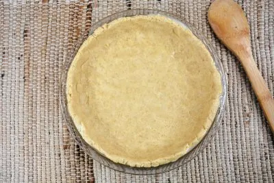 Pressing dough into bottom of pie dish