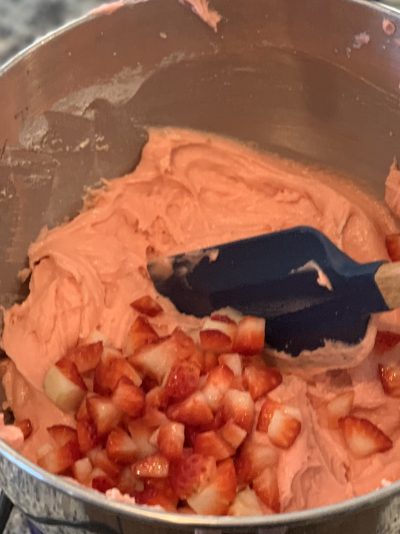 Folding fresh strawberries into cake batter