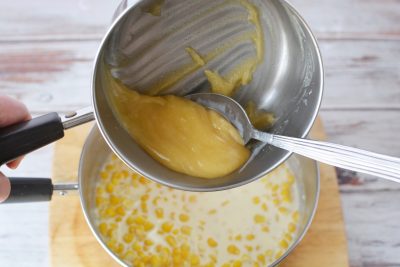 Adding butter mixture to creamed corn