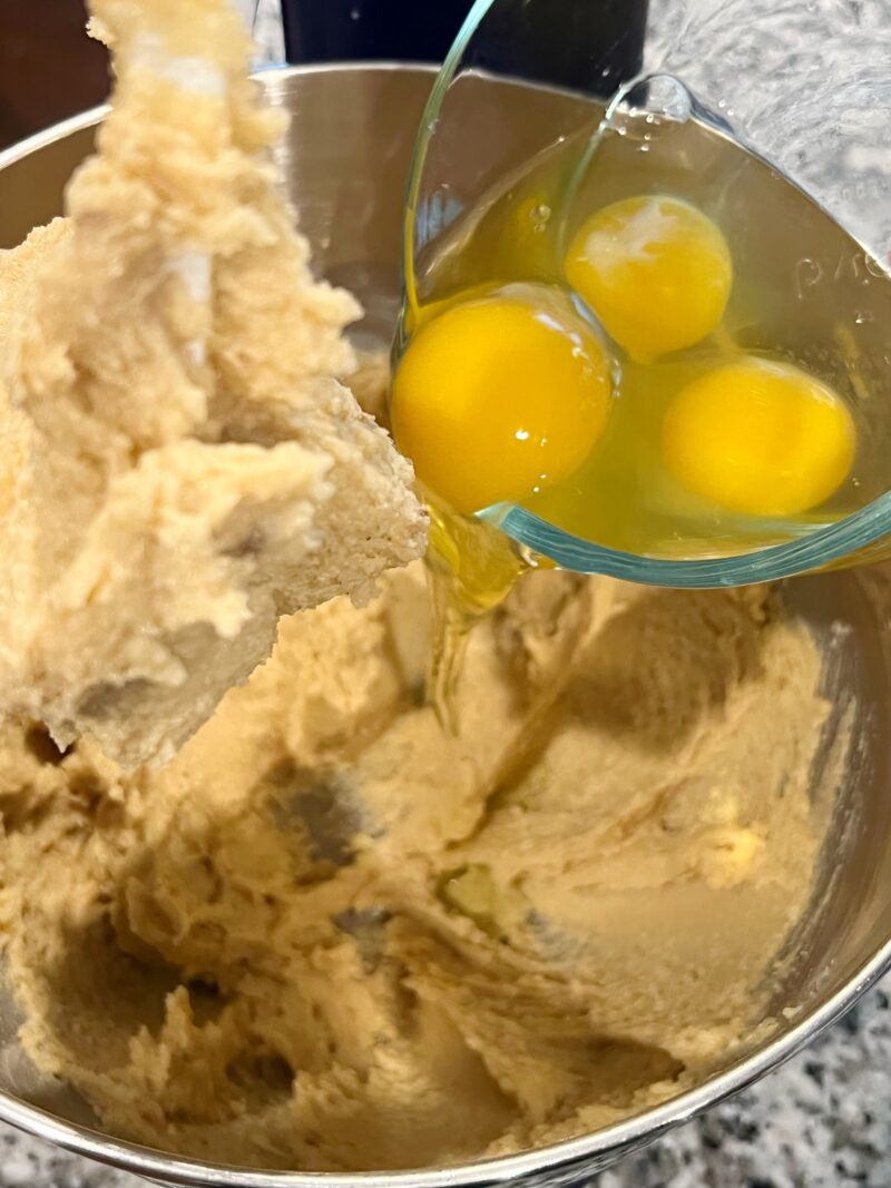 Adding eggs to cake batter and mixing