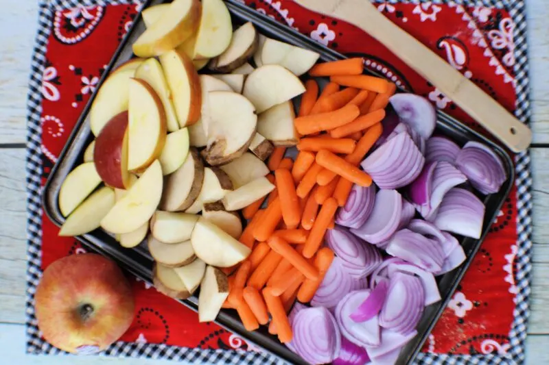 Adding vegetables to chicken sheet pan