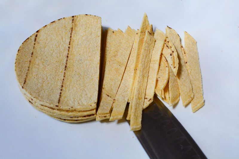 Slicing corn tortillas for topping