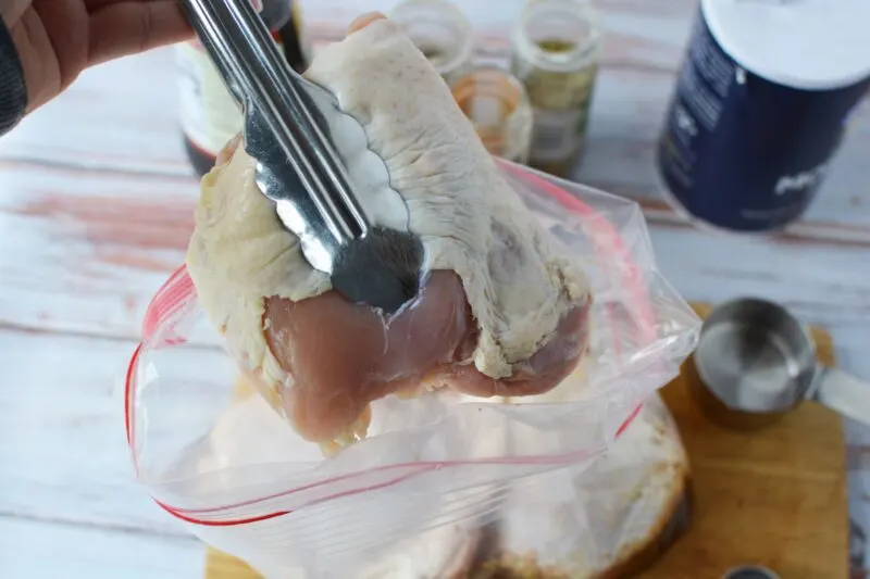 Adding chicken pieces to the marinade in the freezer bag