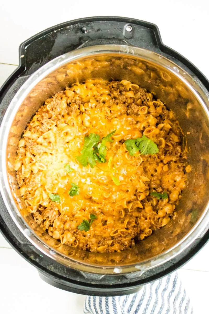 Adding the cheese to the Taco Pasta to cook.