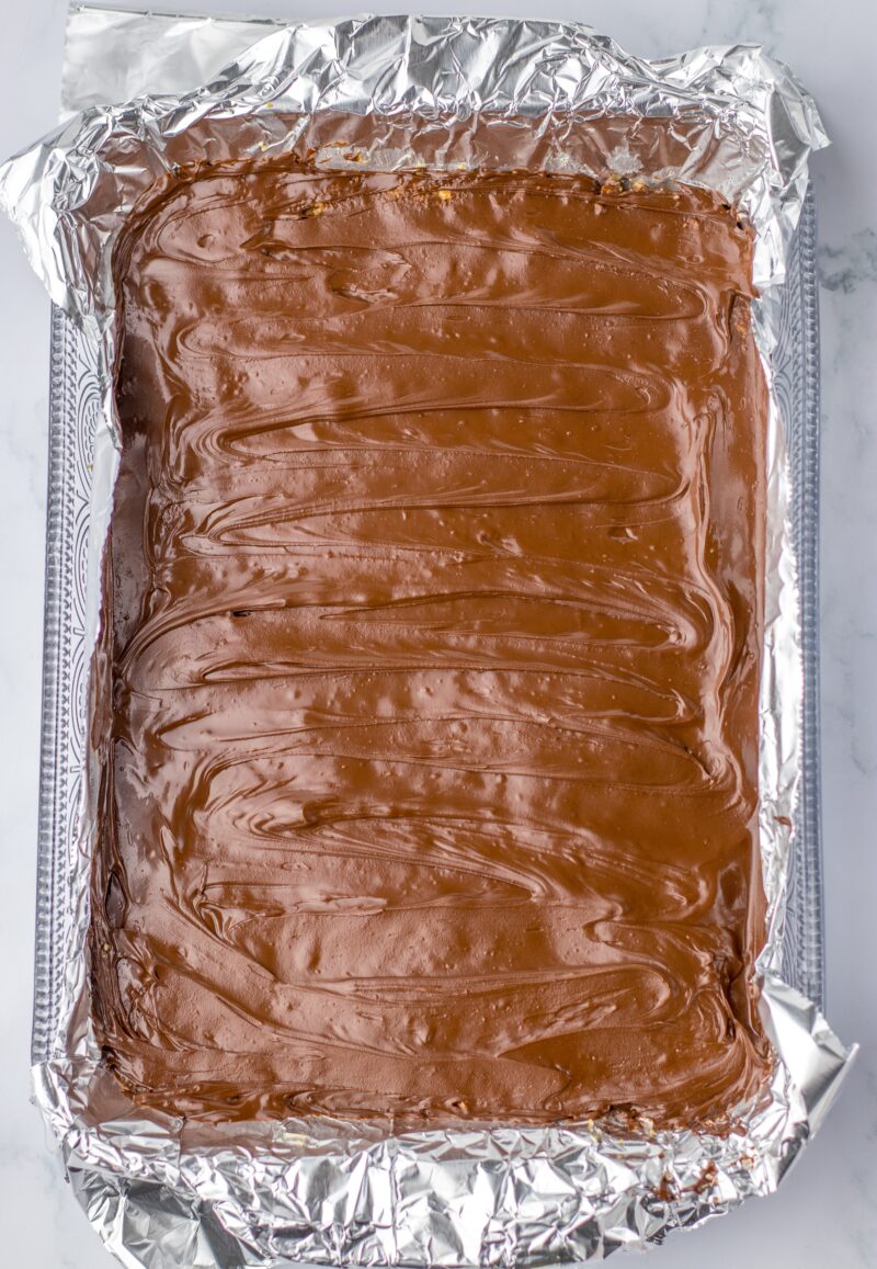 Adding the layer of chocolate on top of the pretzel bottom