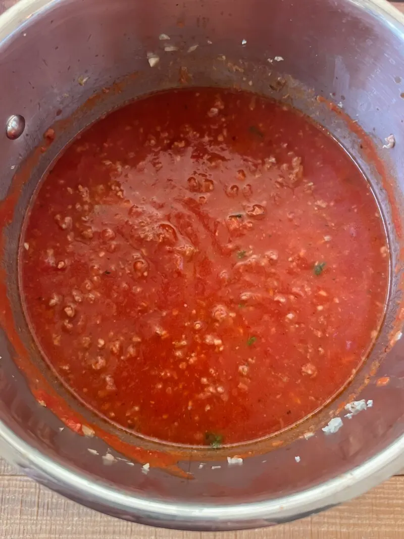 Adding the tomato sauce and paste.