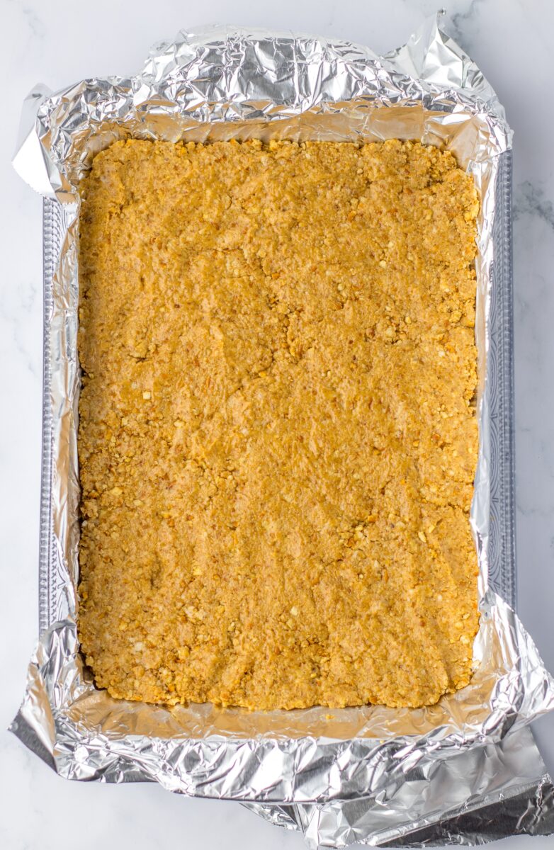 Adding the pretzel crust to the bottom of the baking dish