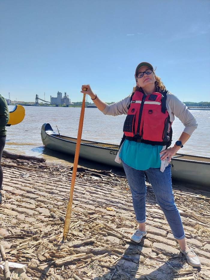 Woman with paddle in front of river