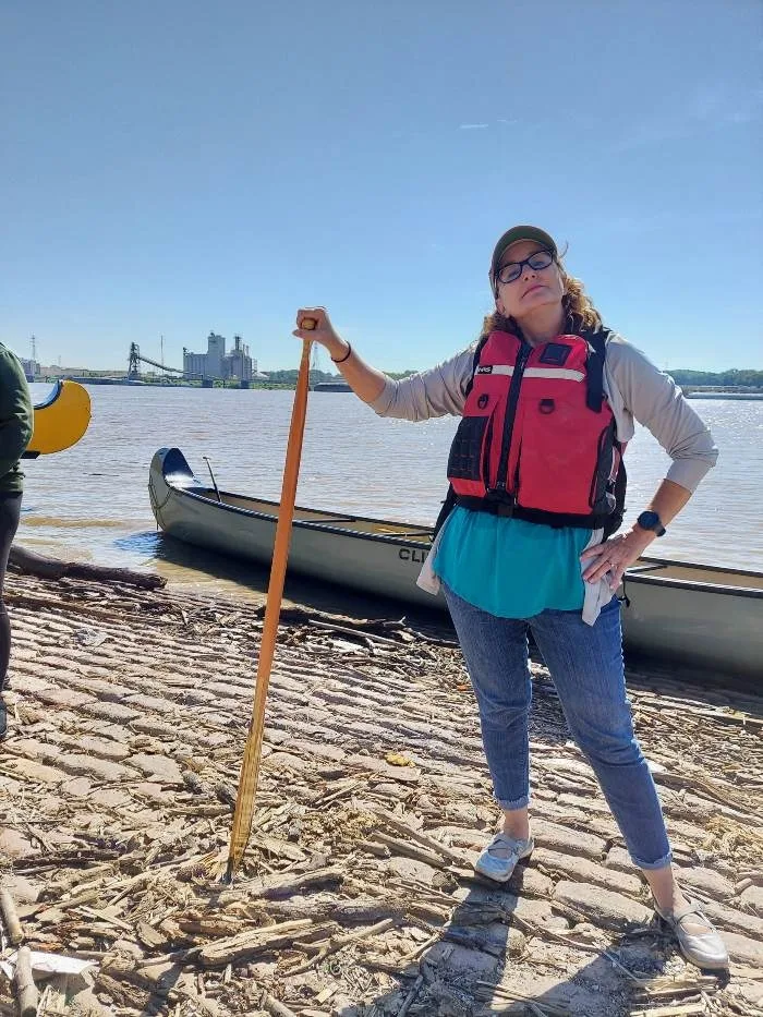 Woman with paddle in front of river