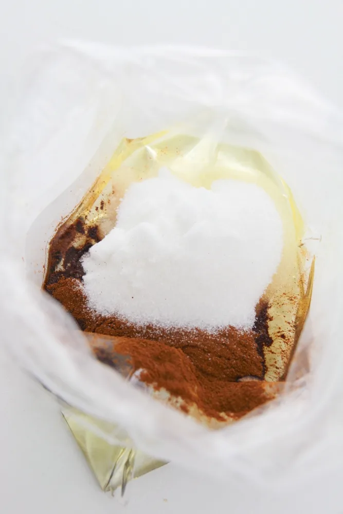 Adding the cinnamon sugar ingredients together in a large freezer bag.