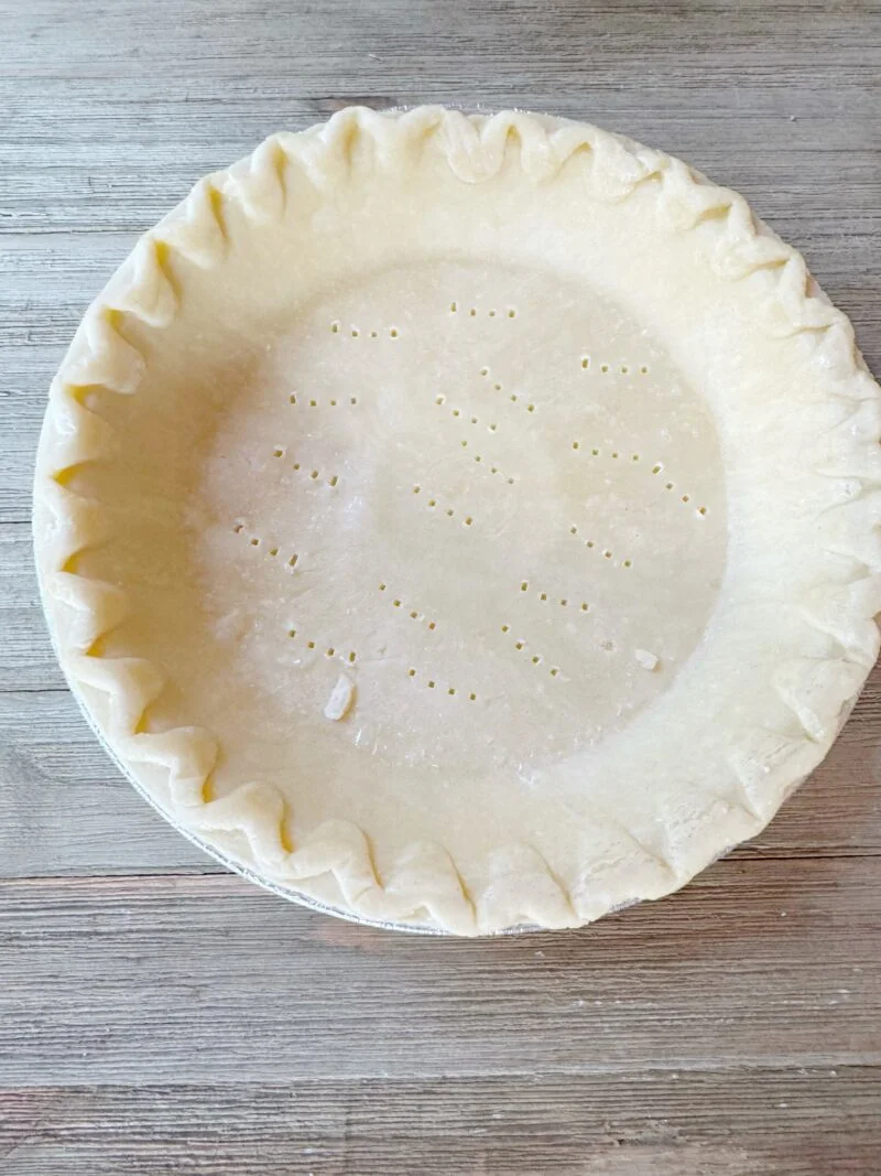 Preparing the pie crust for baking
