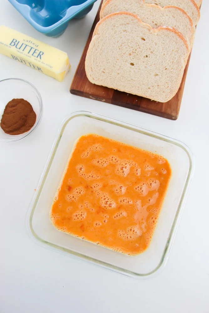 Whisking the eggs and the pumpkin puree until combined.