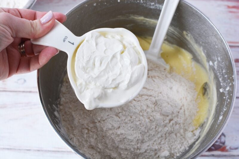 Alternating the sour cream addition with the flour mixture.