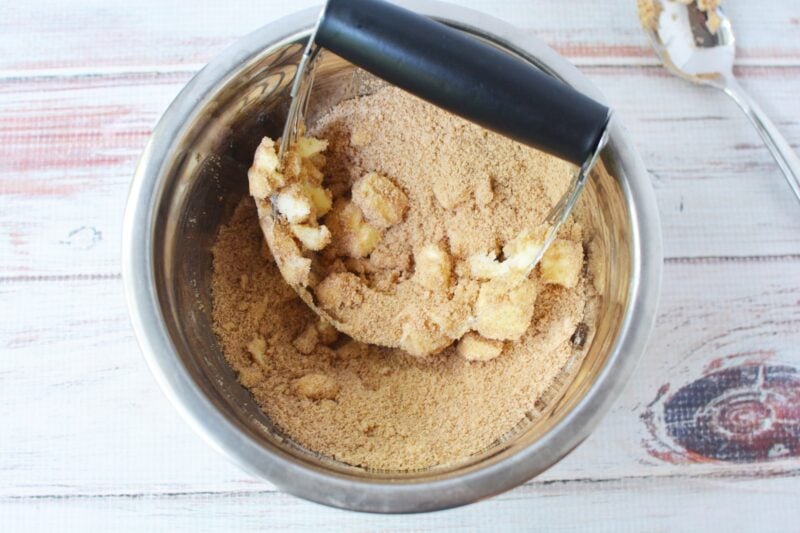Cutting butter into flour and brown sugar to make a streusel