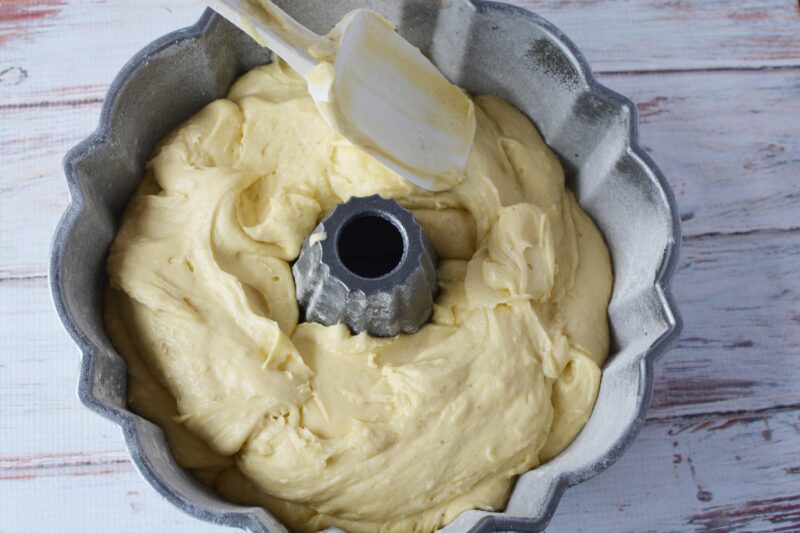 Spooning the Old-Fashioned Sour Cream Cake batter into the bundt cake pan.