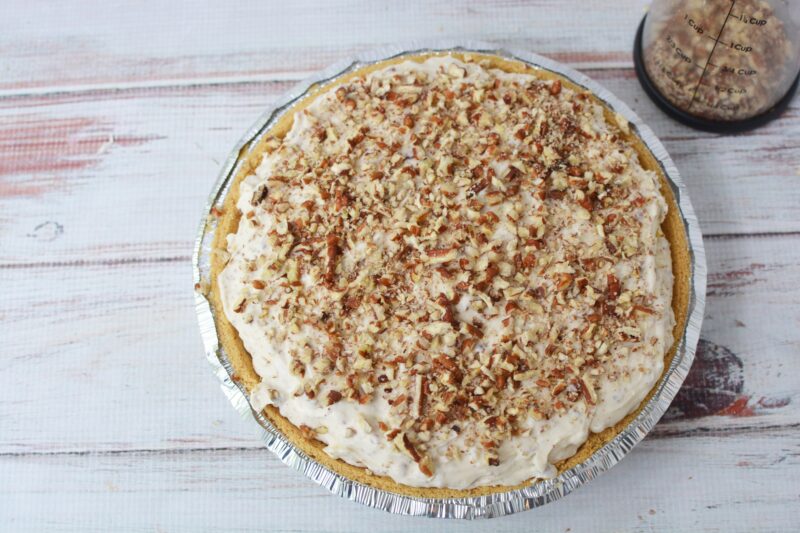 Topping the pie with chopped pecans