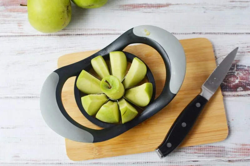 Granny Smith apple being sliced with an apple cutter