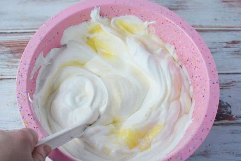 Mixing the whipped topping into the pudding mixture.