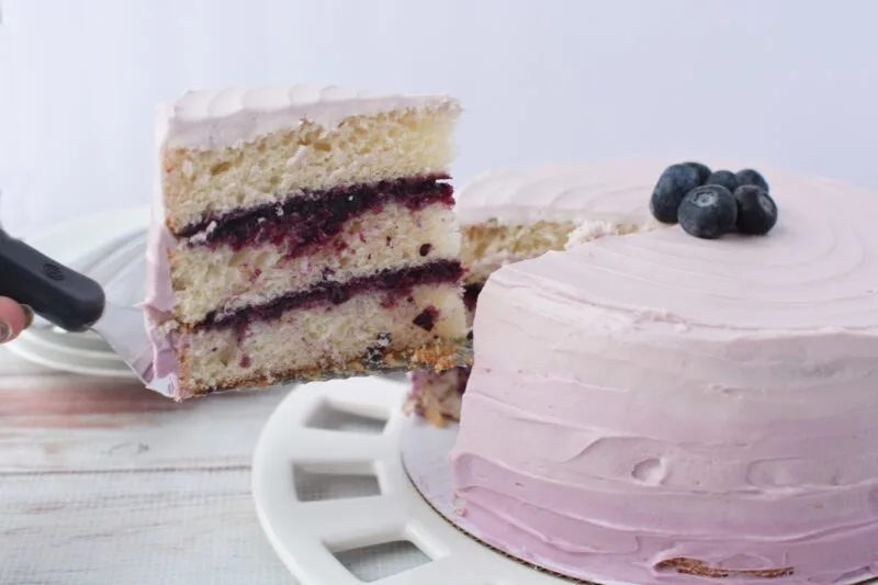 Pulling a layered slice of Blueberry Jam Cake
