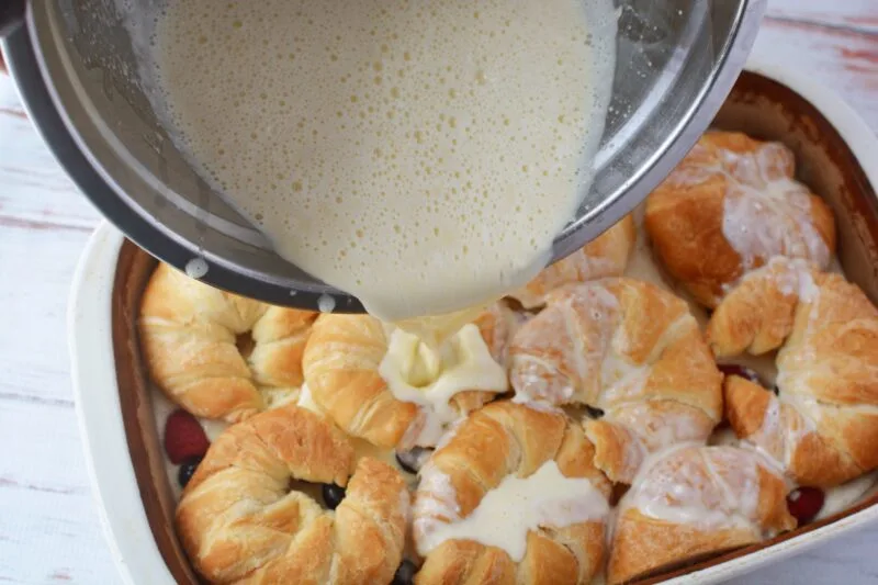 Pouring the remaining custard on top of the casserole