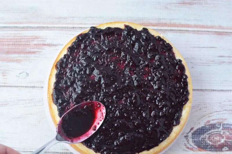 Spreading the blueberry jam between cake layers