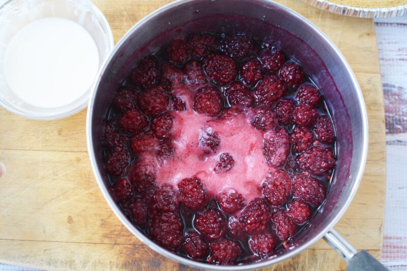 Heating the blackberries in a stovetop for the topping