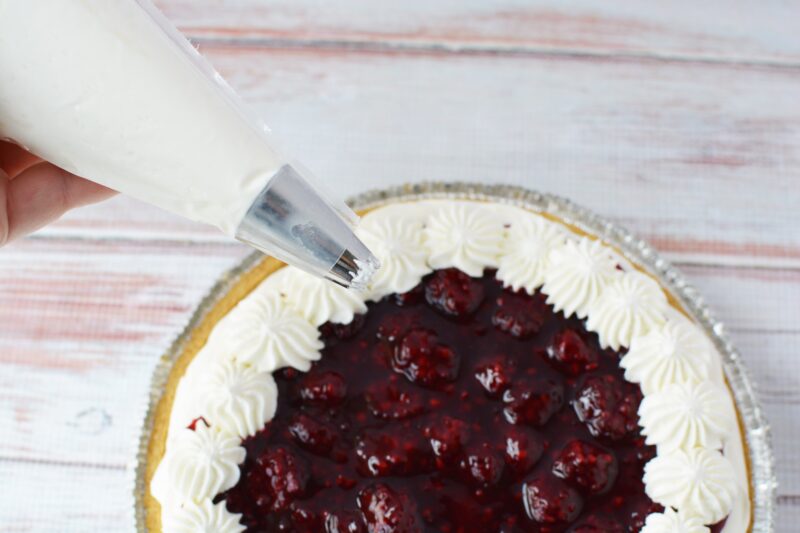 Adding the piped topping the blackberry cream pie