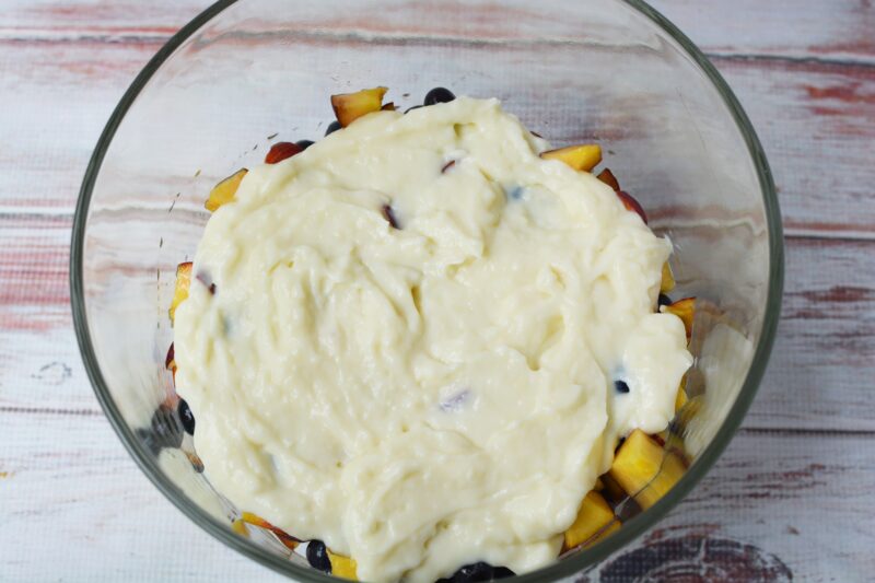 Pouring pastry cream over the top of the fruit