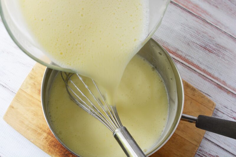 heating the mixture and tempering the egg yolk