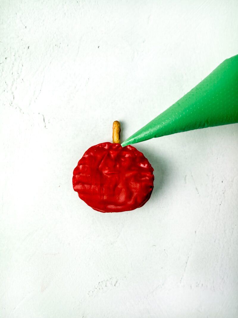 Piping the green onto the apple from the piping bag